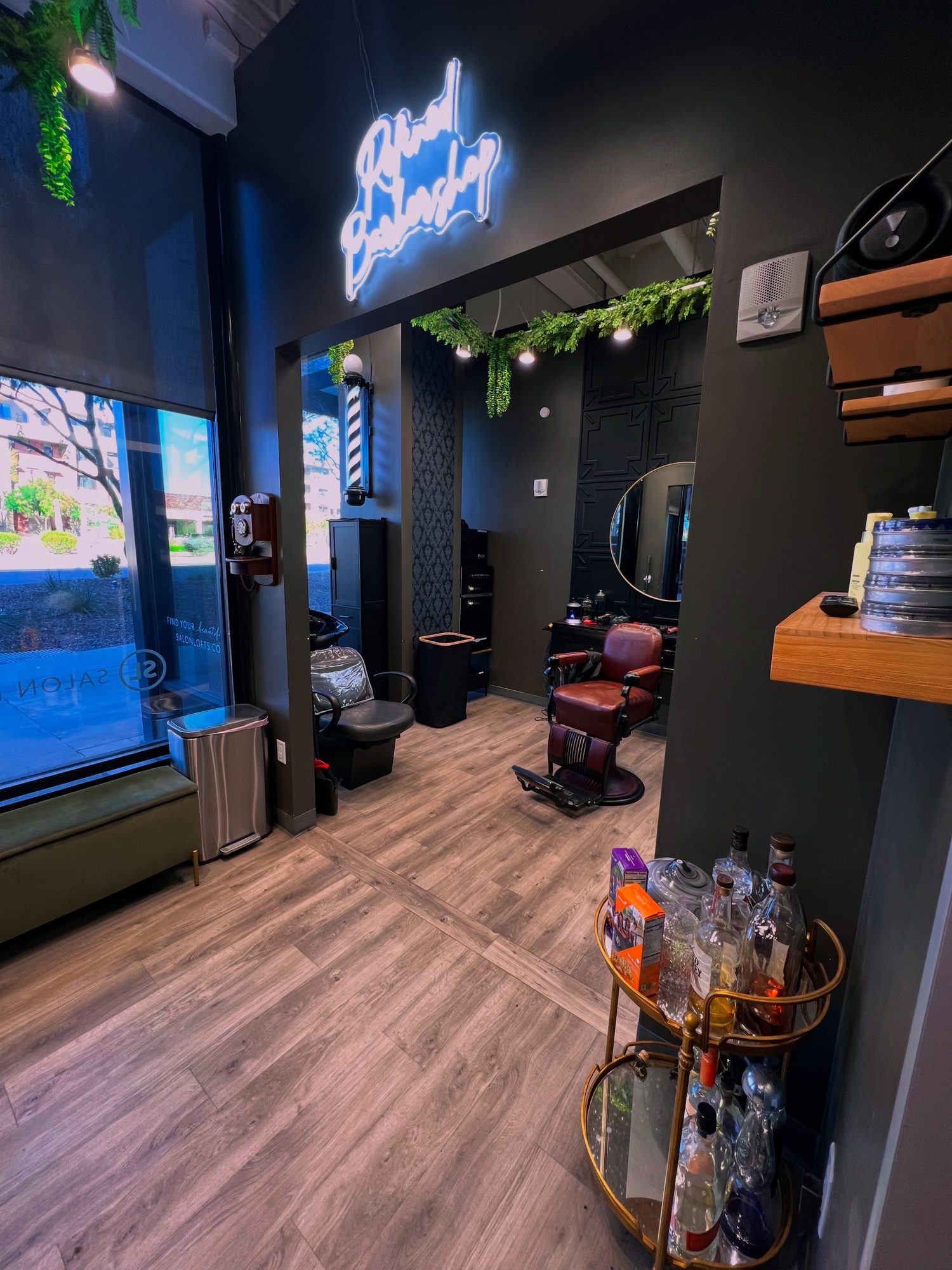 Inside Refined Barbershop, the neon sign over the chairs